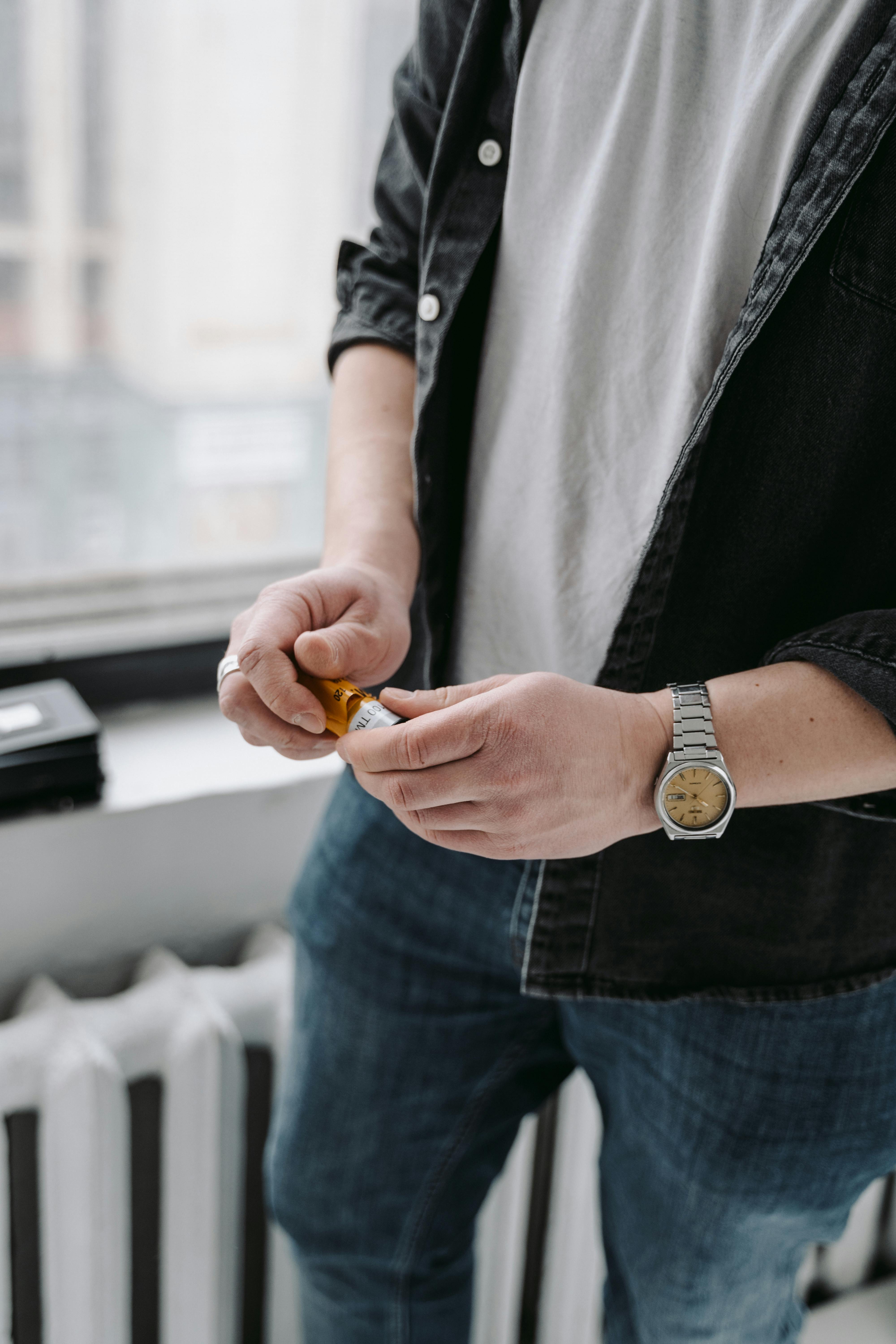 Person in Blue Denim Jeans Holding Film Cartridge · Free Stock Photo