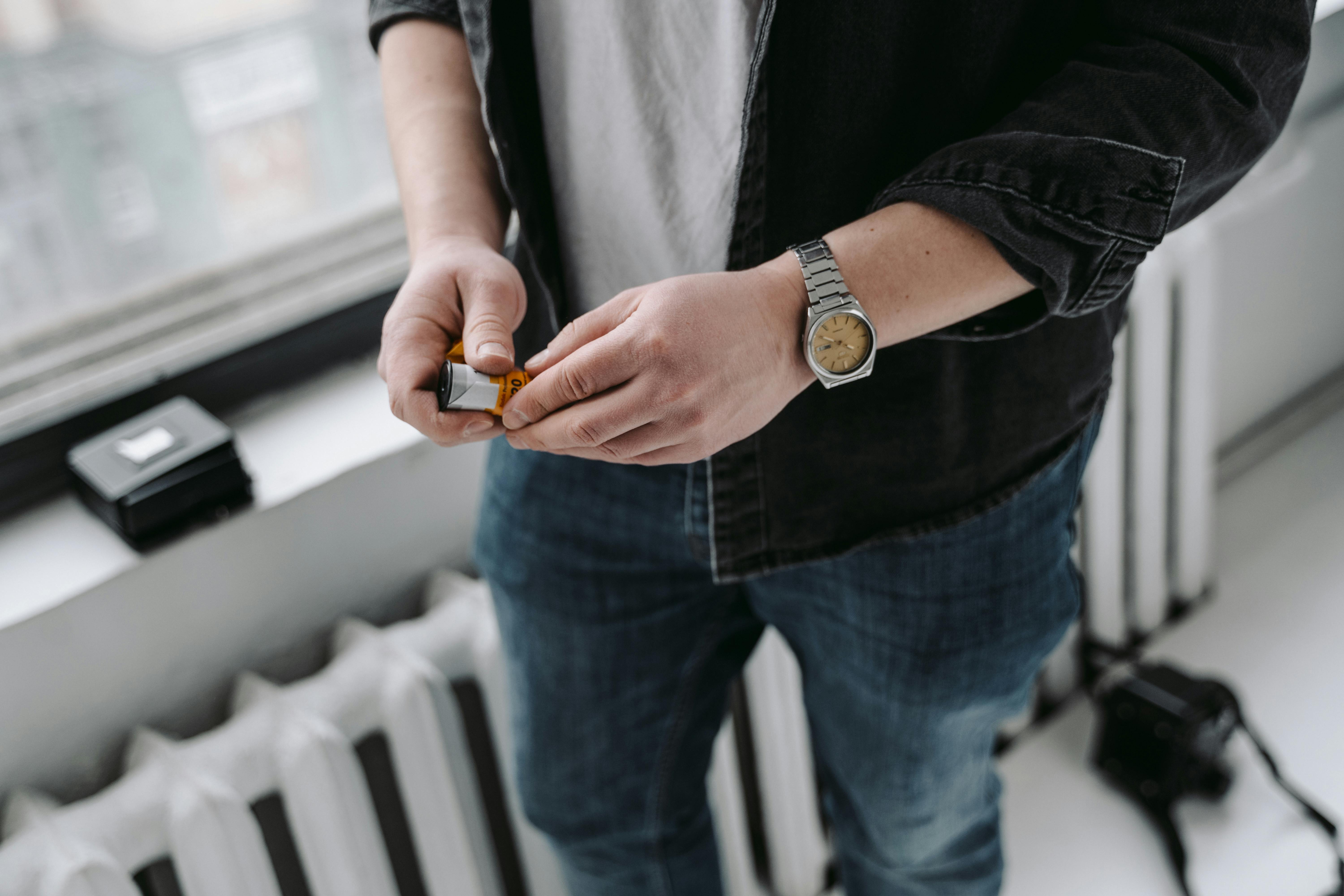 Person in Blue Denim Jeans Holding Film Cartridge · Free Stock Photo