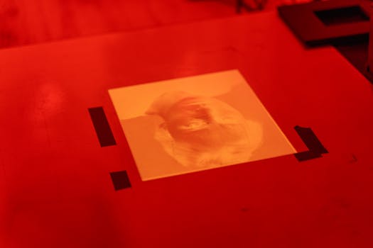 A vintage film negative displayed on a red-lit darkroom table, evoking nostalgia and classic photography techniques.