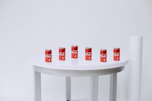 Red Coca-Cola Tin Cans Arranged on a Table