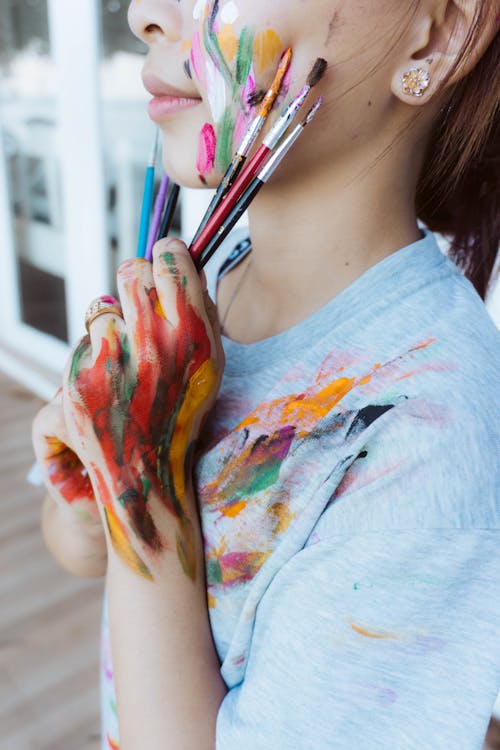 Close-Up Shot of a Person Holding Paint Brushes