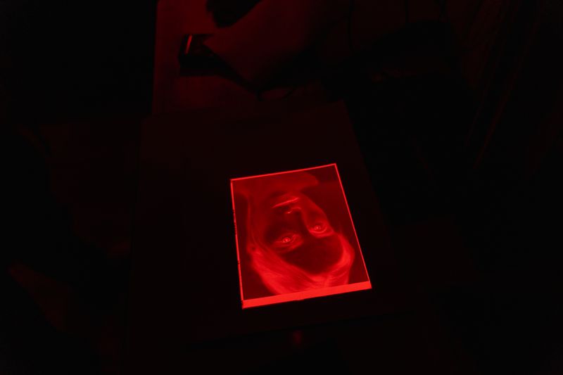 a print under red safelight in a darkroom — photograph by Tima Miroshnichenko on Pexels