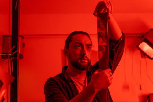 A Photographer Looking at Images on Film Negatives