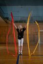 Woman in Black Shirt and White Pants Standing on Yellow and Red Rope