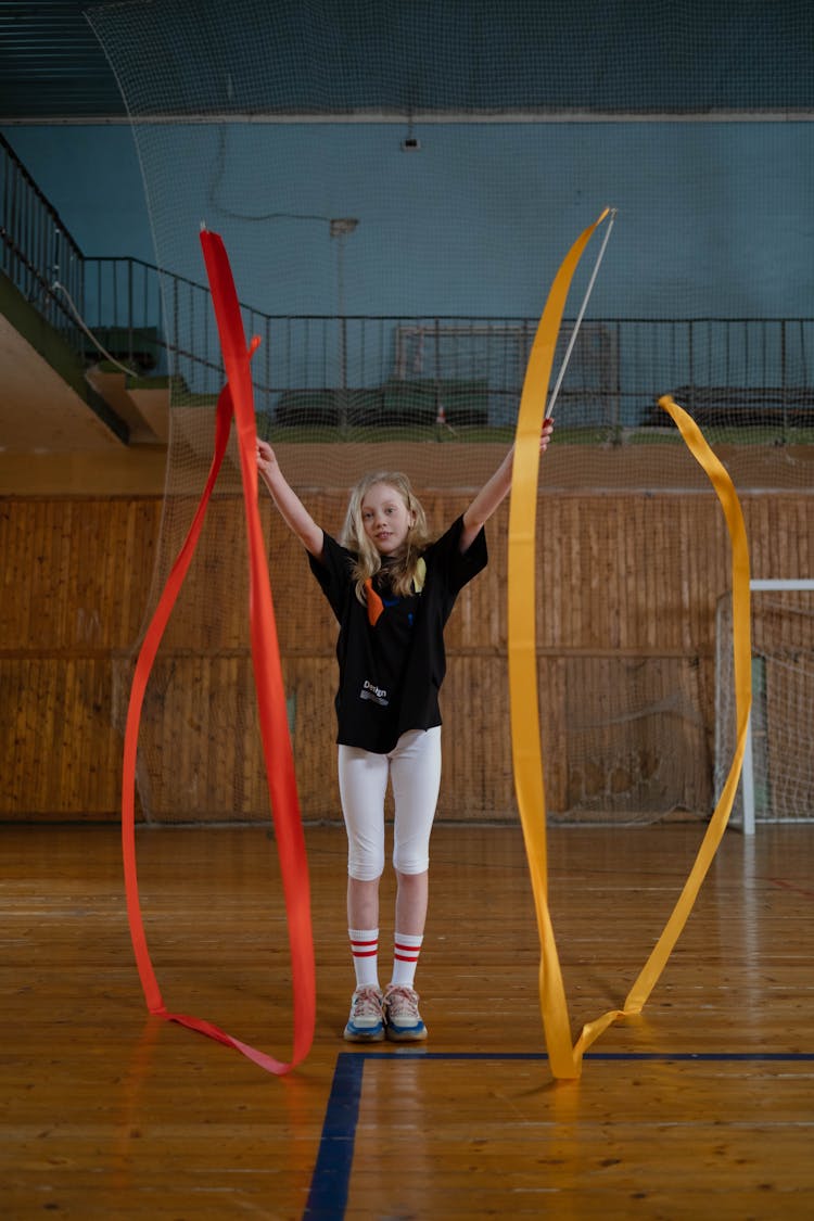 A Girl Holding Sticks With Ribbons 