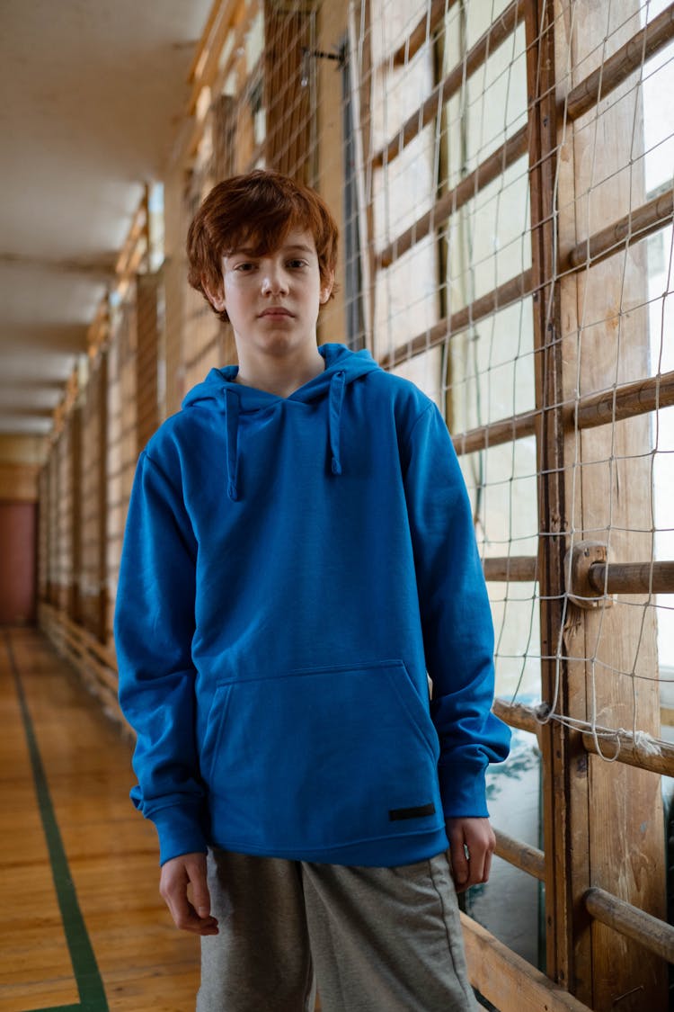 A Boy Wearing Blue Hoodie Sweater And Gray Shorts 