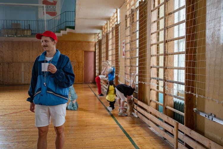 A Male Physical Education Teacher Coaching His Students