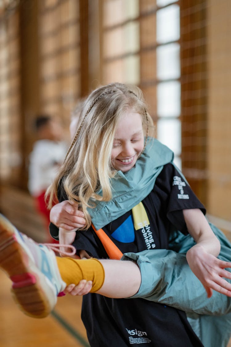 A Smiling Girl Holding A Leg Of A Person