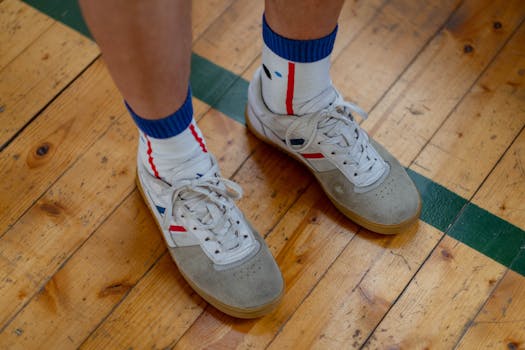 Close-up of sneakers and socks on a gym floor, capturing a casual sporty look.