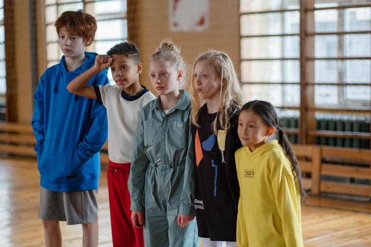 Shallow Focus Photo Of Teens Standing Inside The Gym