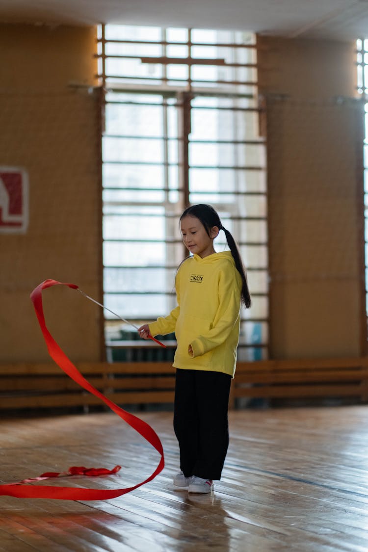 A Girl In Yellow Hoodie Doing Gymnastics