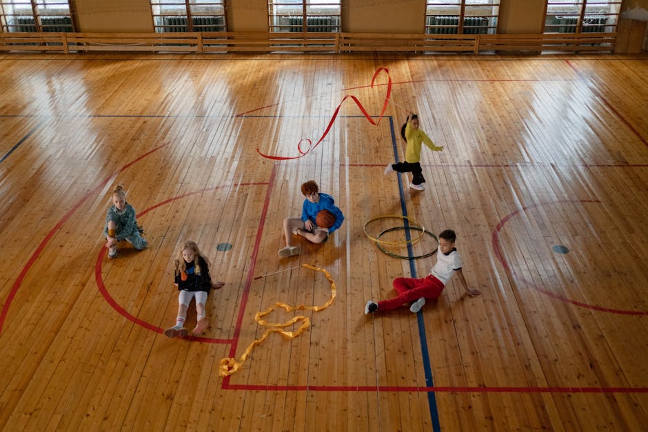 Mikä on liikunnanopettaja? Mikä on liikunnanopettaja? - Children playing various games in an indoor gym with wooden floors, showcasing recreational fun.