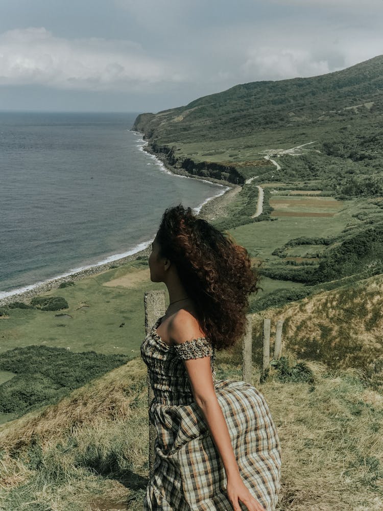 Woman In Plaid Dress Standing On Mountain Top