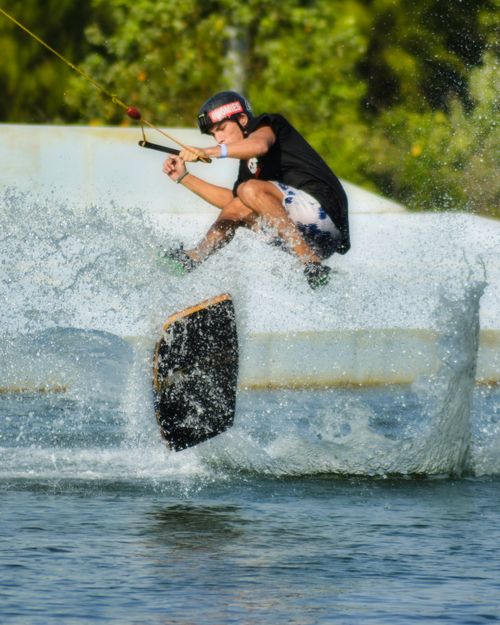 Free Exciting shot of a wakeboarder performing a trick on a sunny day in Phuket, Thailand. Stock Photo