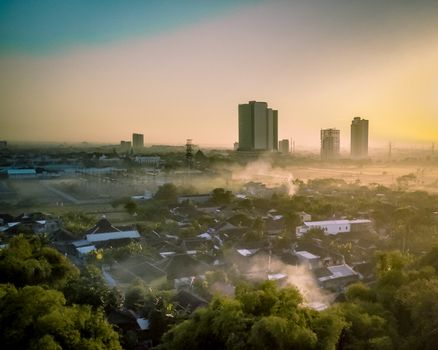 Aerial view of Sekadau Hilir at sunrise, showcasing urban skyline and morning fog.
