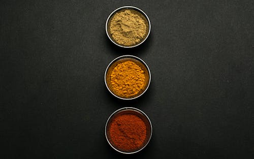 Close-Up Shot of Bowls of Powder Condiments