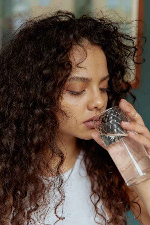 Foto profissional grátis de bebendo, cabelo cacheado, copo de água