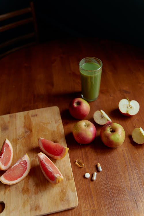 Sliced Apple Beside Sliced Apple and Green Liquid in Clear Drinking Glass