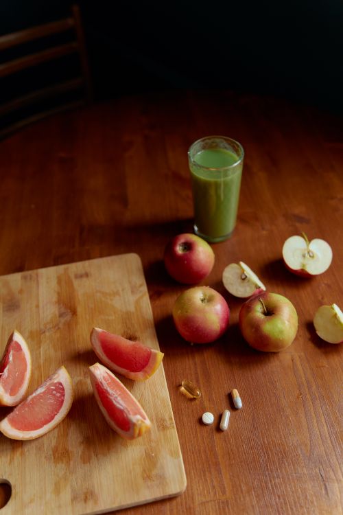 Free A vibrant display of fresh fruits, grapefruit, apples, and a glass of green juice, symbolizing health. Stock Photo