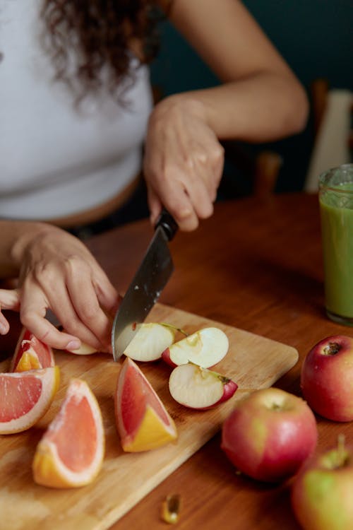 A Person Slicing an Apple on a Chopping Board