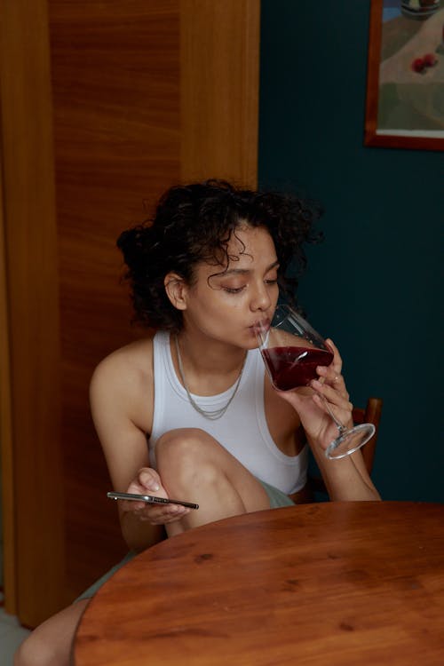 Woman in White Tank Top Drinking Wine