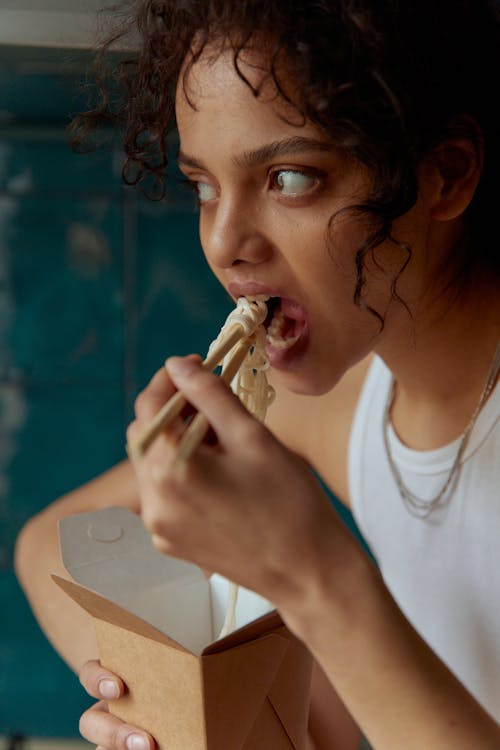 Woman in White Crew Neck T-shirt Eating Food