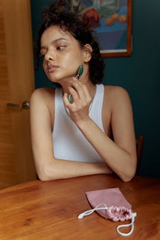 Adult woman using a jade face roller for skincare at home. Promotes self-care and beauty routines.