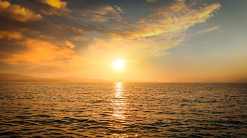 Free Captivating ocean sunset with golden sky reflecting on tranquil sea, perfect for serene backgrounds. Stock Photo