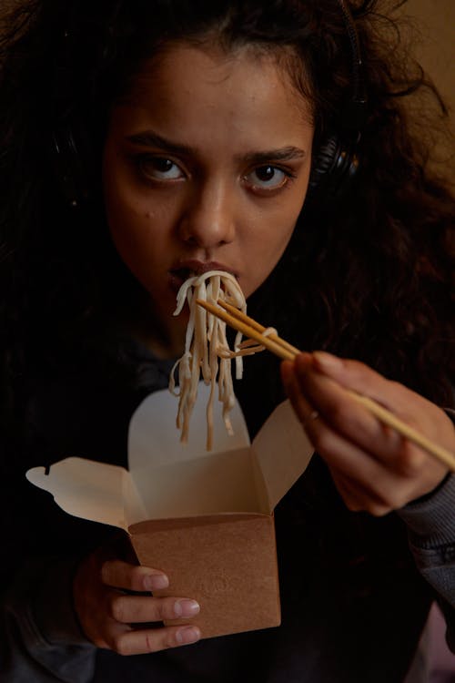 A Woman Eating Noodles while Using Chopsticks