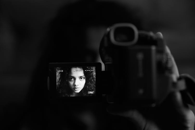 Grayscale Photography Of Woman Taking Video Of Herself