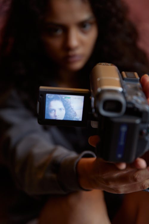 A Woman Filming Herself Using a Video Camera · Free Stock Photo