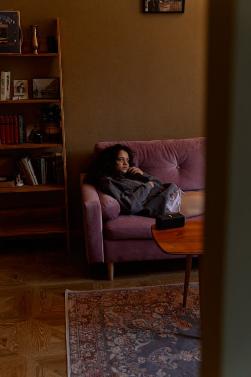 A Woman Lying Down on the Couch Looking Lonely