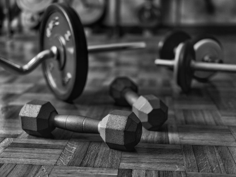 Grayscale Photo of Dumbbells on the Floor · Free Stock Photo