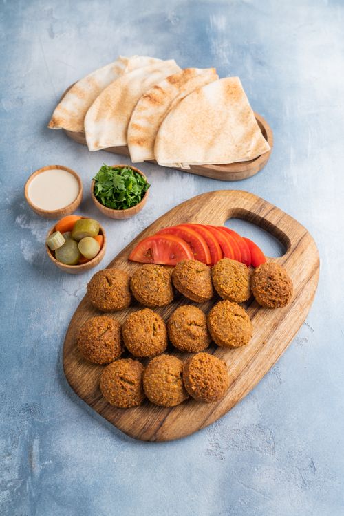 Free A delicious falafel platter with fresh pita, vegetables, and sauces, ideal for food photography. Stock Photo