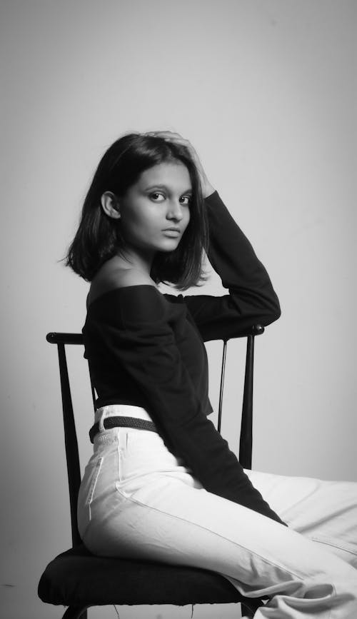 Young Indian woman in trendy outfit on chair