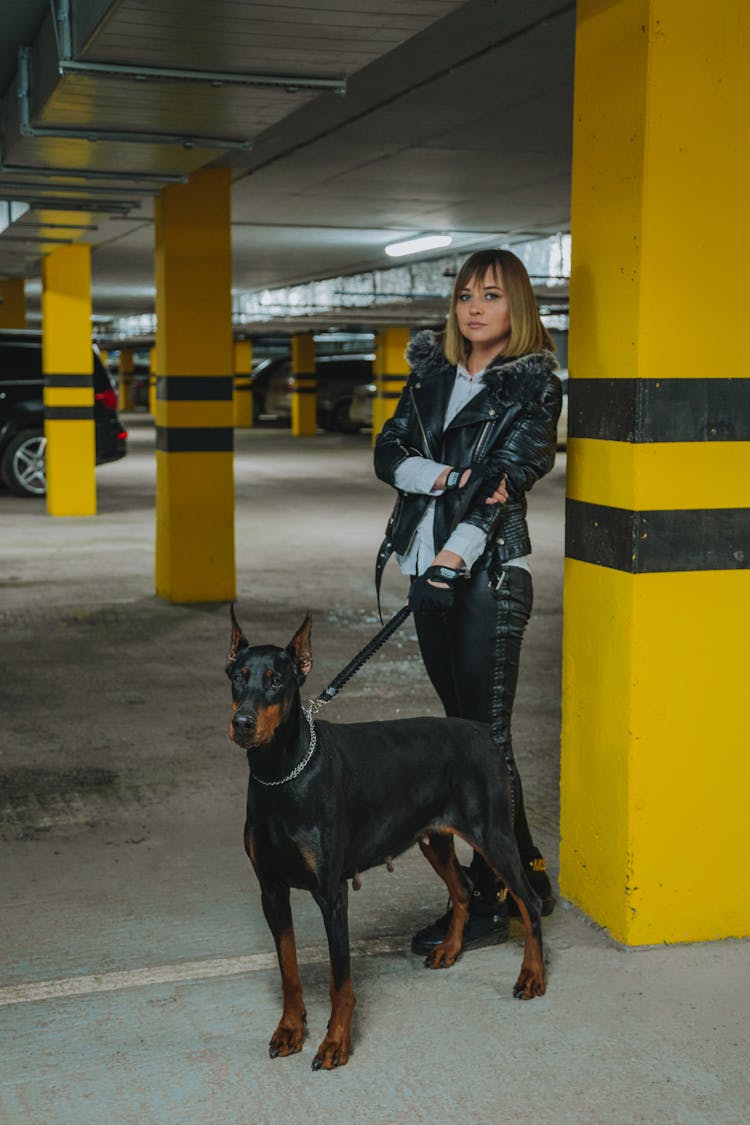 Woman With Doberman On Parking Lot