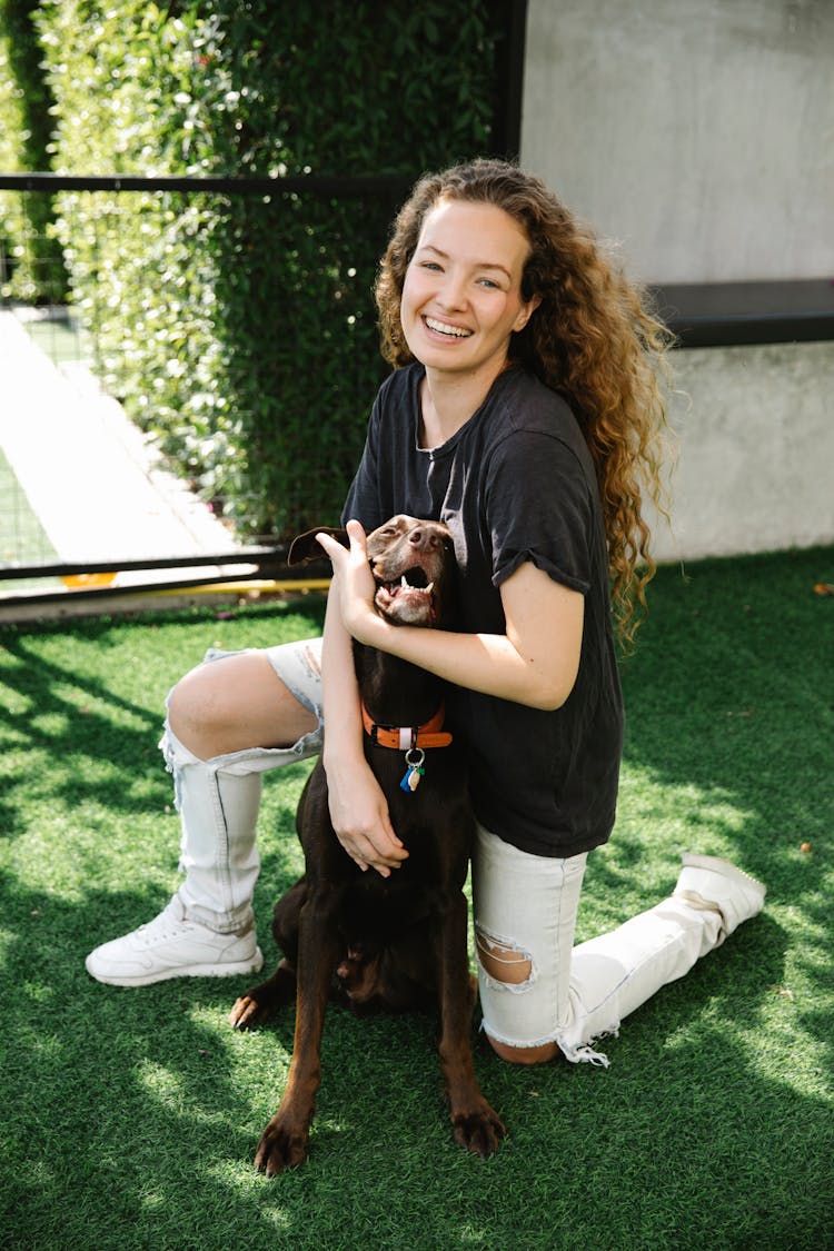 Glad Woman Embracing Bird Dog On Lawn