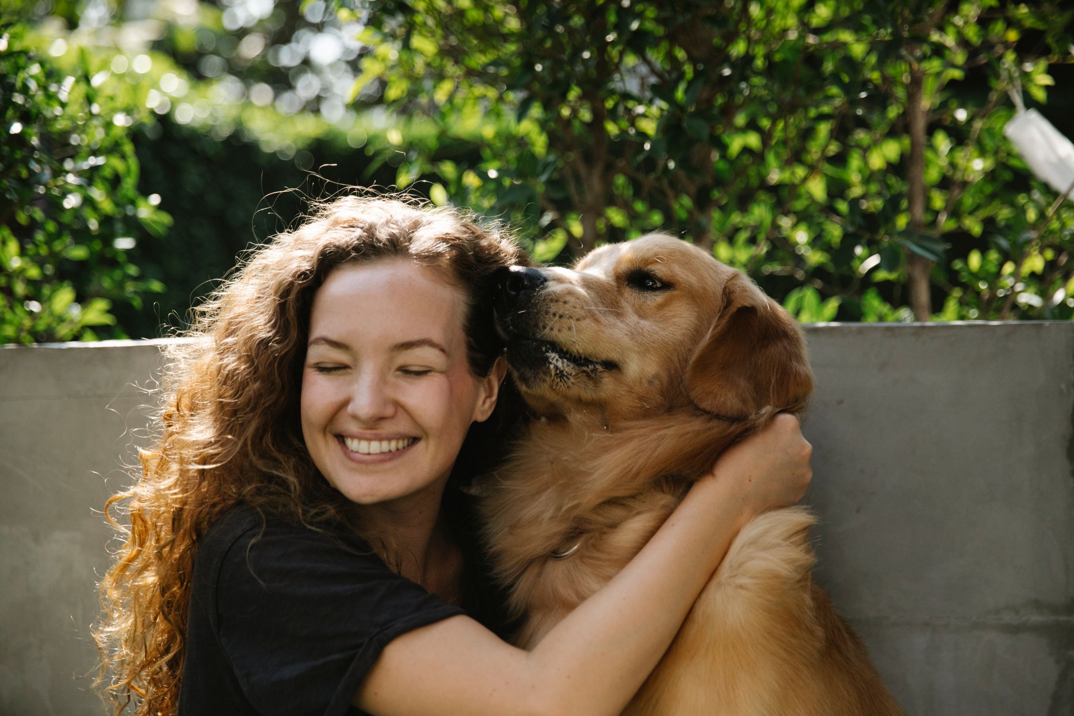 Pet caregiver and golden retriever outdoors