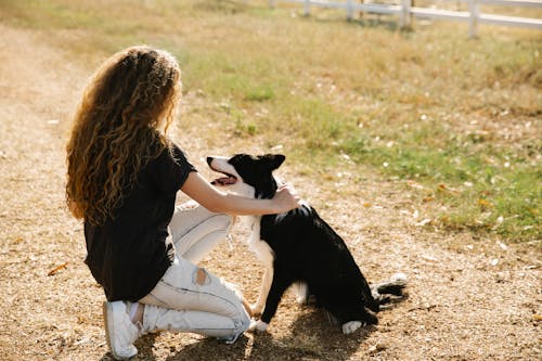 Женщина и ее собака на сельской грунтовой дороге