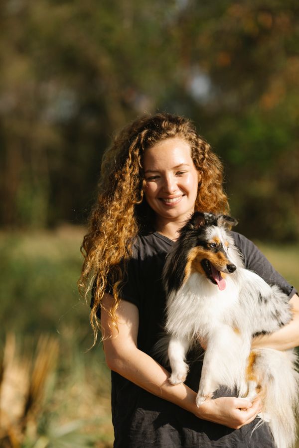 Dr. Maya Hart smiling while holding a Shetland sheepdog