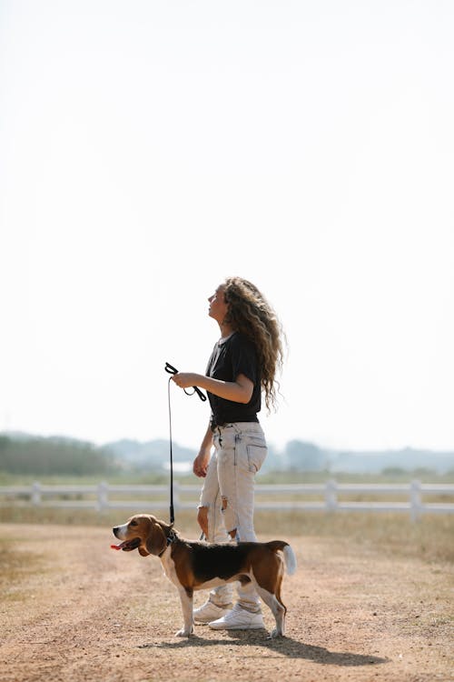 Woman standing with purebred dog on leash