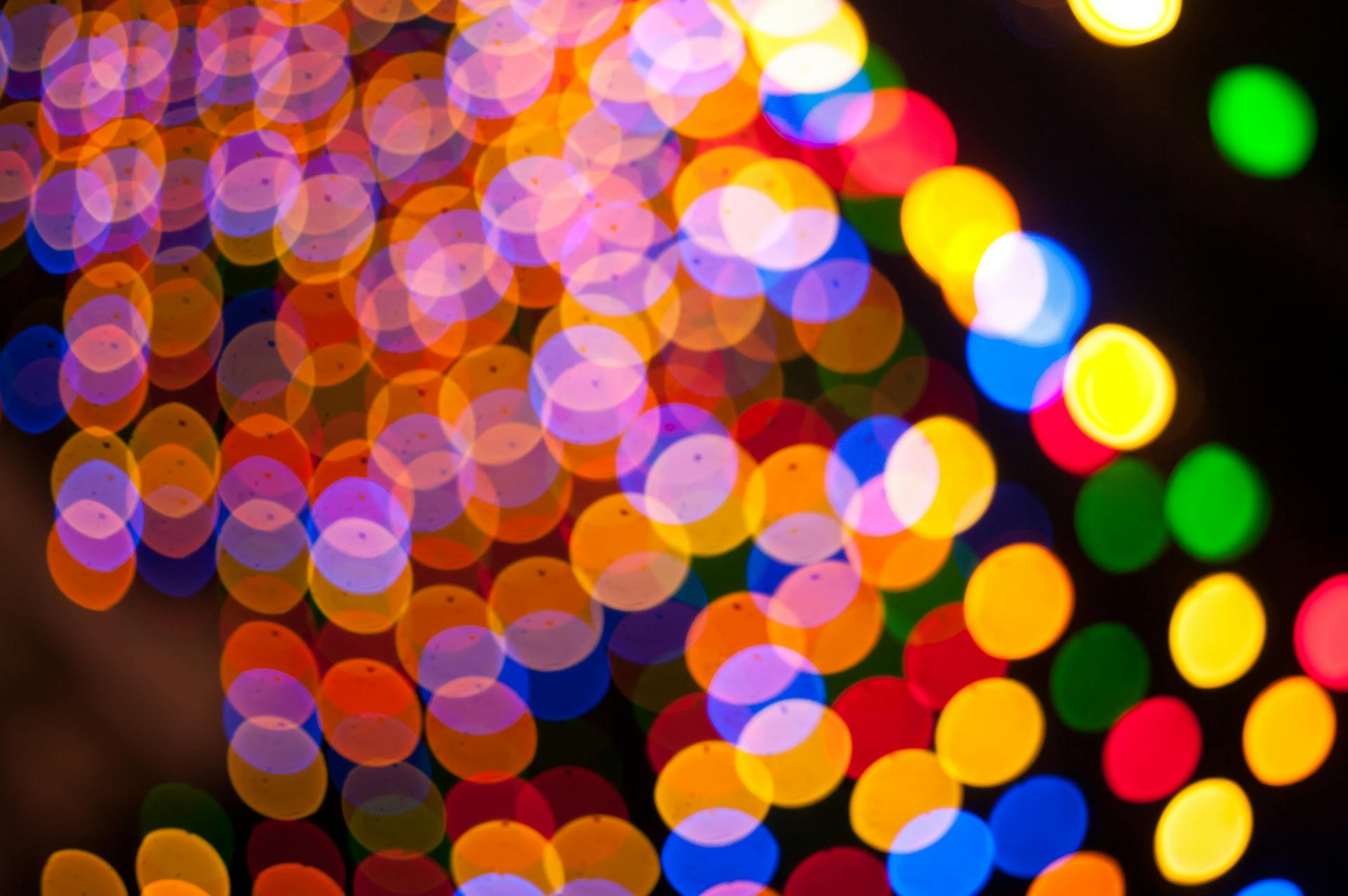 Colorful circular bokeh lights create a festive and abstract pattern with vibrant colors.