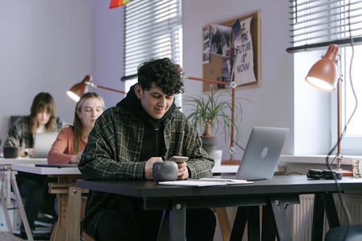 Group of young adults in a contemporary workspace using technology devices.