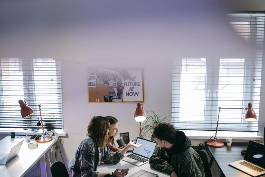 A team discussing work around laptops in a modern office