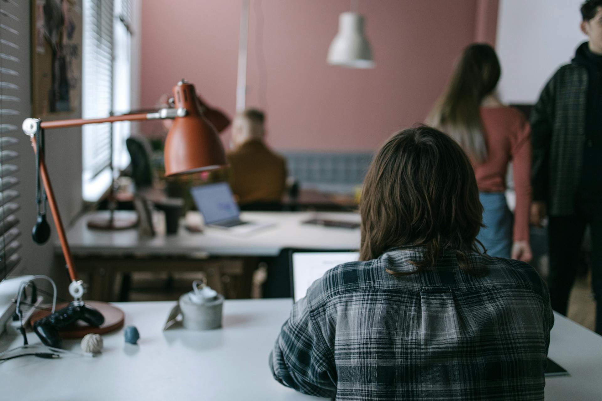 A contemporary coworking space with individuals working at their desks, showcasing a collaborative environment.