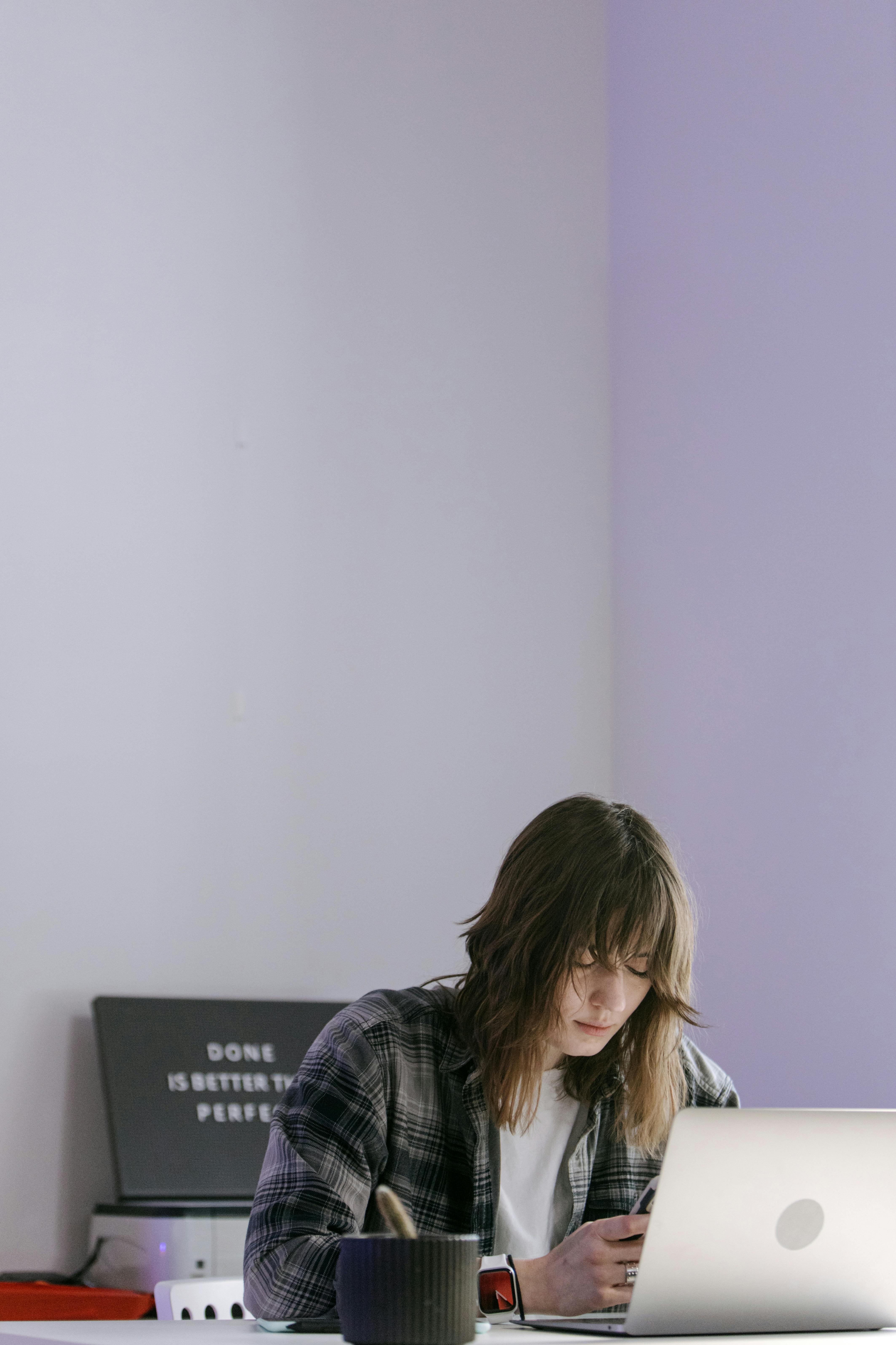 Woman Using Cellphone and a Laptop