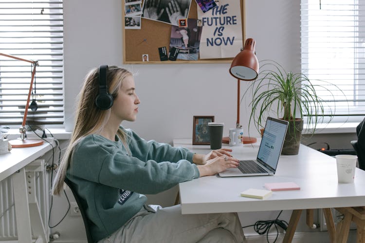 Woman Wearing Headphones Using Laptop