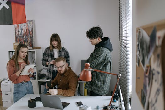 Group of young professionals having a team meeting around a laptop in a modern startup office.