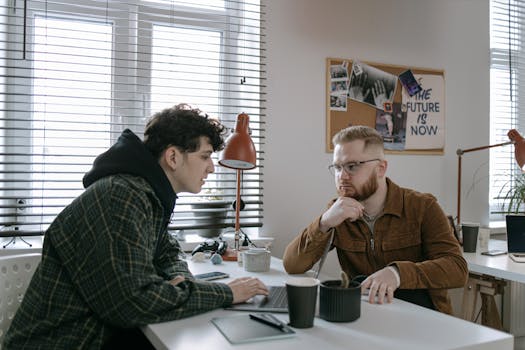 Two young professionals engaged in a brainstorming session at a modern office setting.