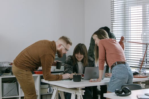 Young professionals brainstorming and sharing ideas at a desk in a contemporary office.